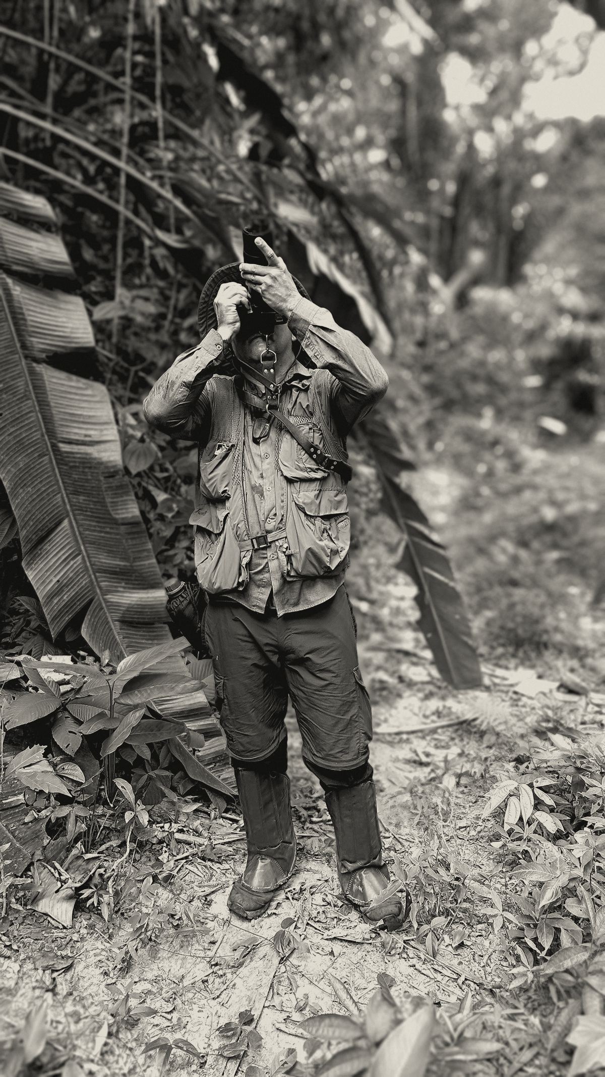 Man in a field vest and boots in the jungle