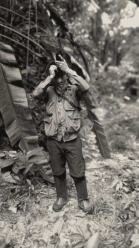 Man in a field vest and boots in the jungle